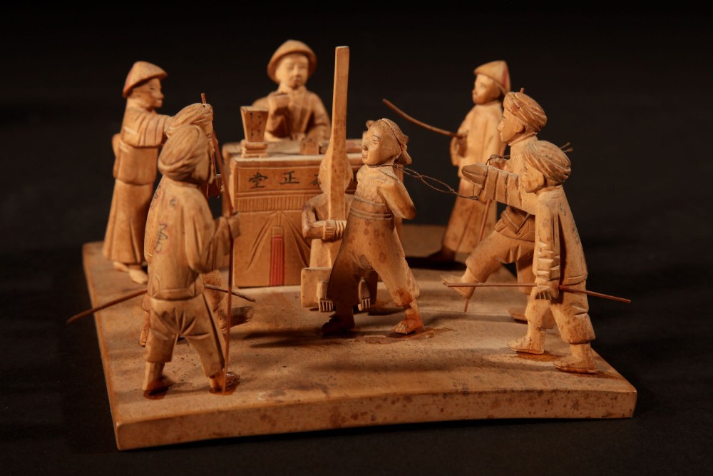 A collection of seven light-coloured Chinese wood carvings depicting figures engaged in traditional daily activities including weaving, fishing, and carrying a sedan chair. View XV