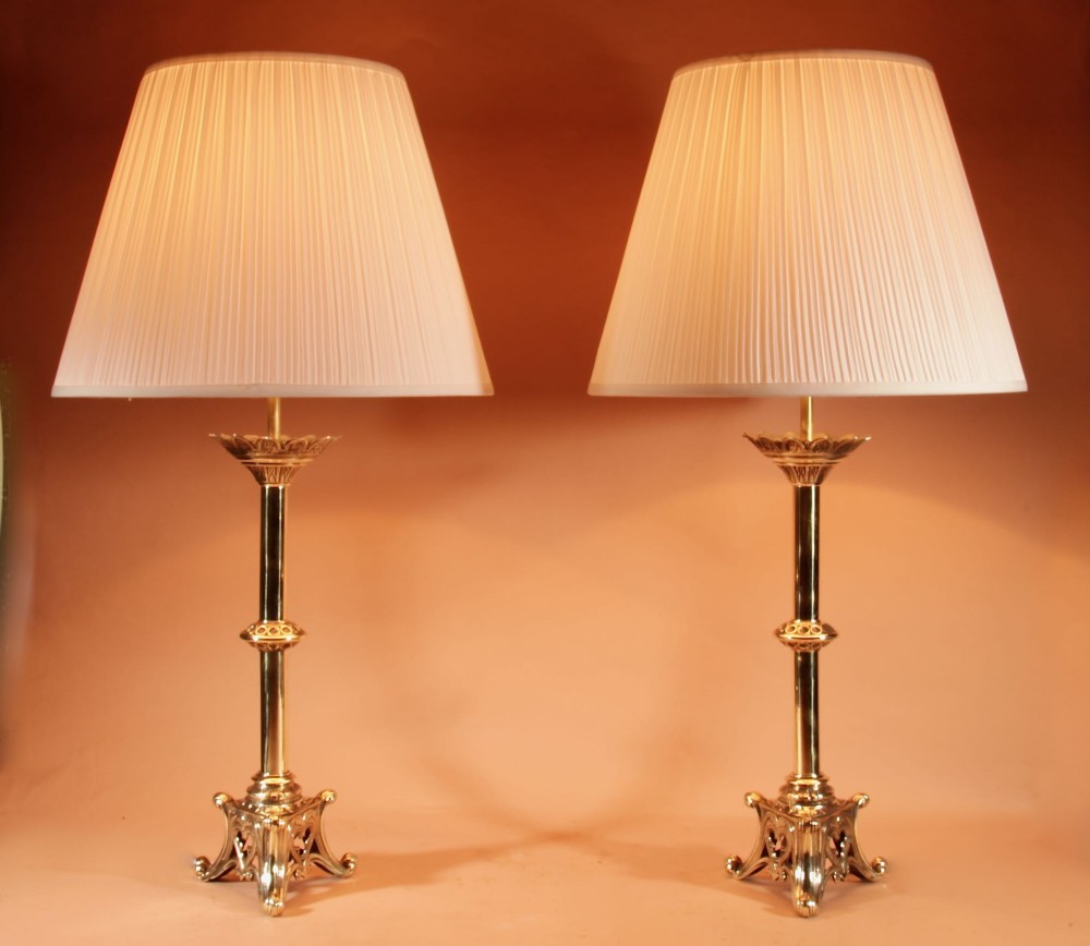 A pair of tall cast brass table lamps featuring Gothic architectural bases and pleated cream shades. View II