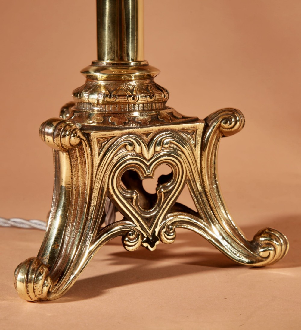 A pair of tall cast brass table lamps featuring Gothic architectural bases and pleated cream shades. View IV