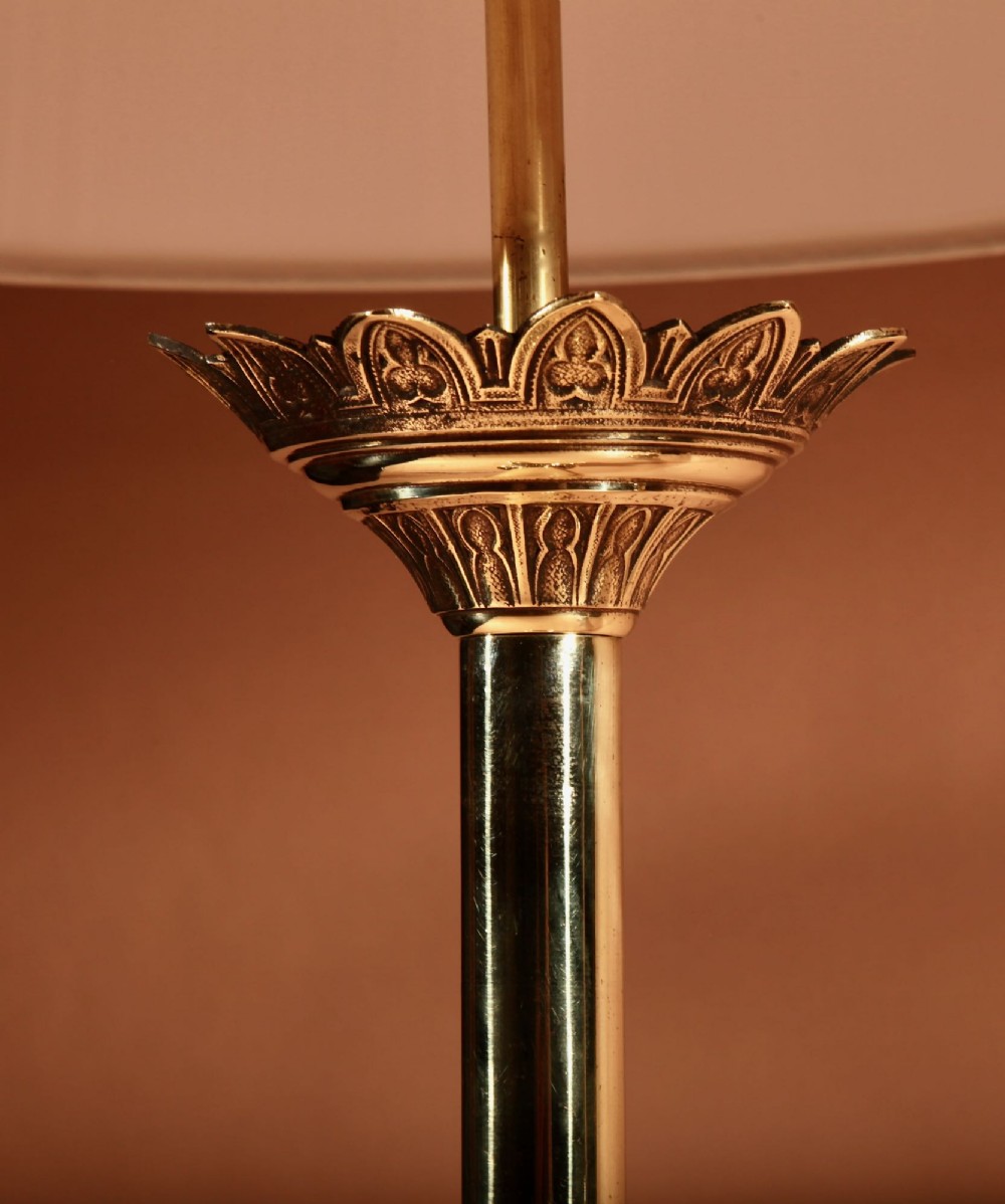 A pair of tall cast brass table lamps featuring Gothic architectural bases and pleated cream shades. View VI