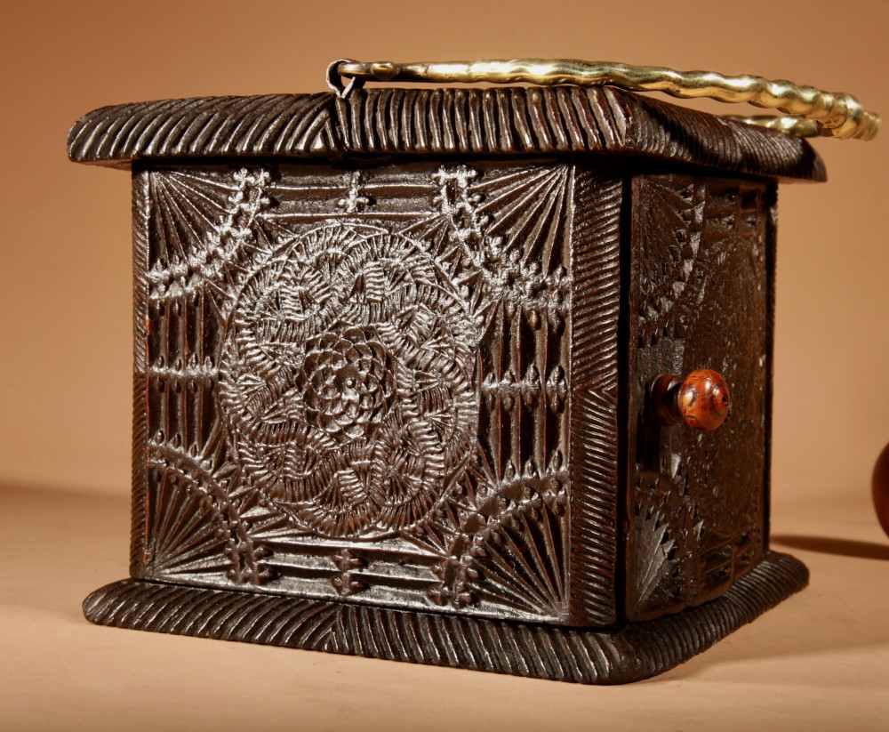 A dark oak foot stove featuring geometric chip carving and a twisted brass handle. View III