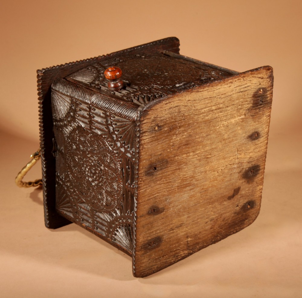A dark oak foot stove featuring geometric chip carving and a twisted brass handle. View VI