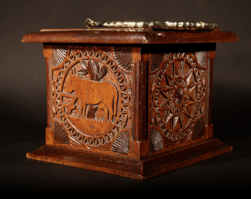 A square chip-carved wooden foot stove dated 1901 featuring relief carvings of animals and a brass carrying handle. View III