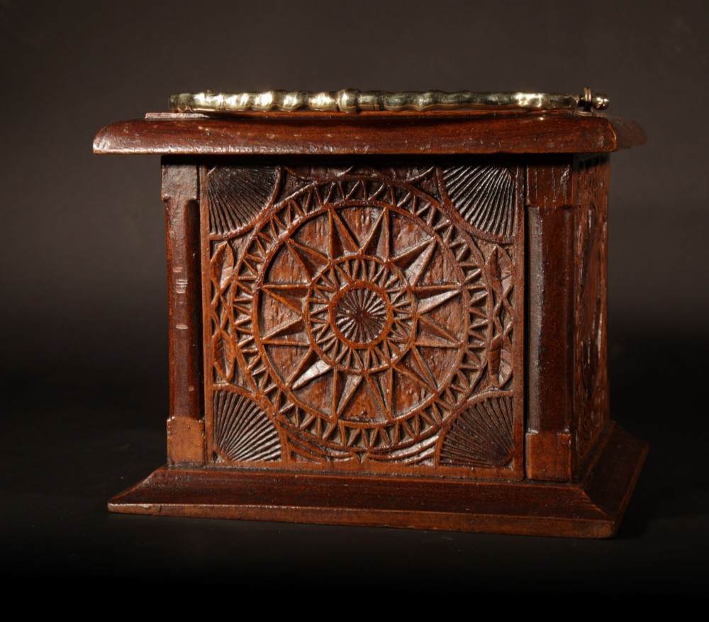 A square chip-carved wooden foot stove dated 1901 featuring relief carvings of animals and a brass carrying handle. View IV