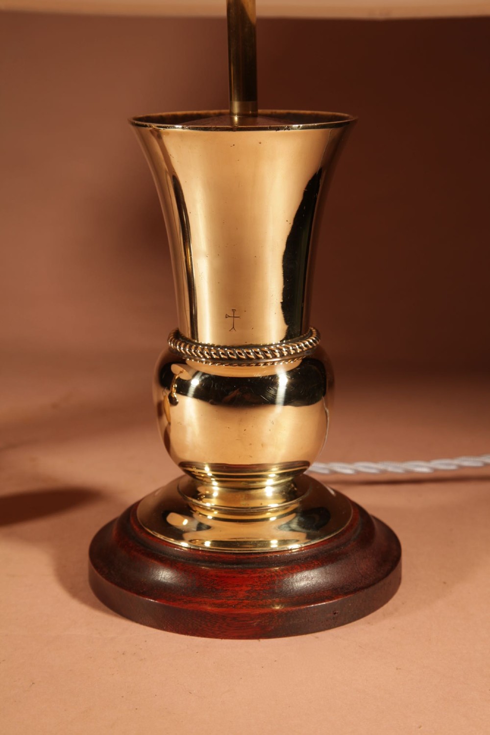 A pair of polished brass table lamps with flared bases on dark wooden plinths, topped with cream pleated shades. View II