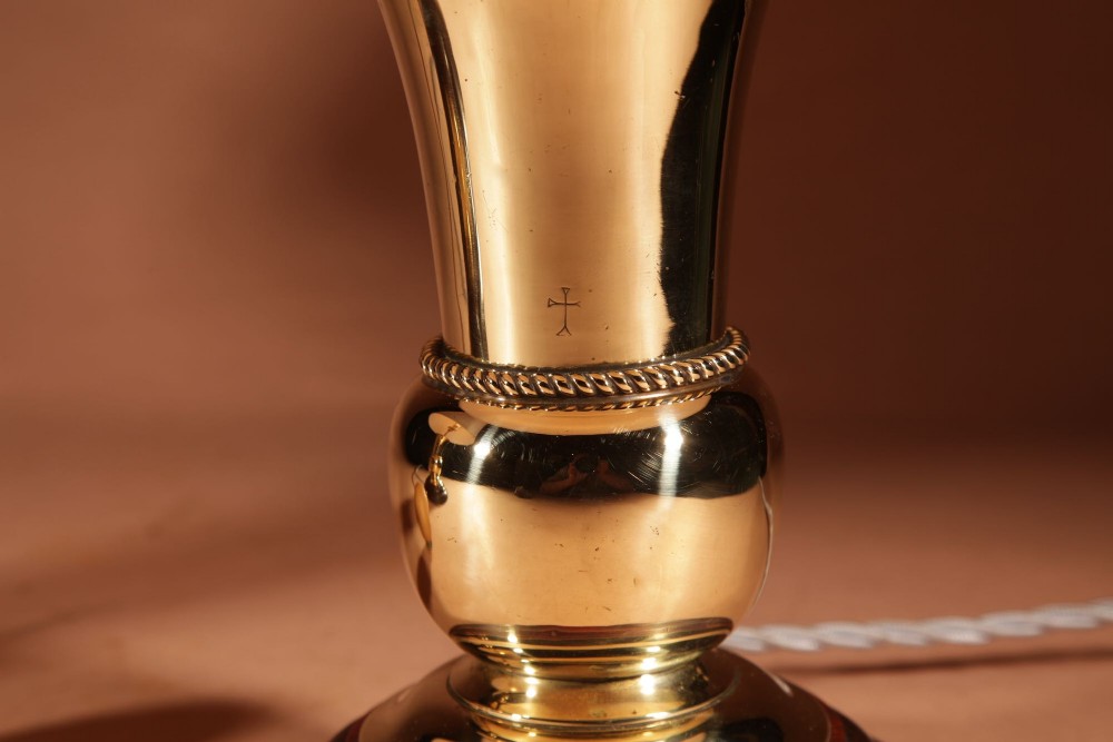A pair of polished brass table lamps with flared bases on dark wooden plinths, topped with cream pleated shades. View III