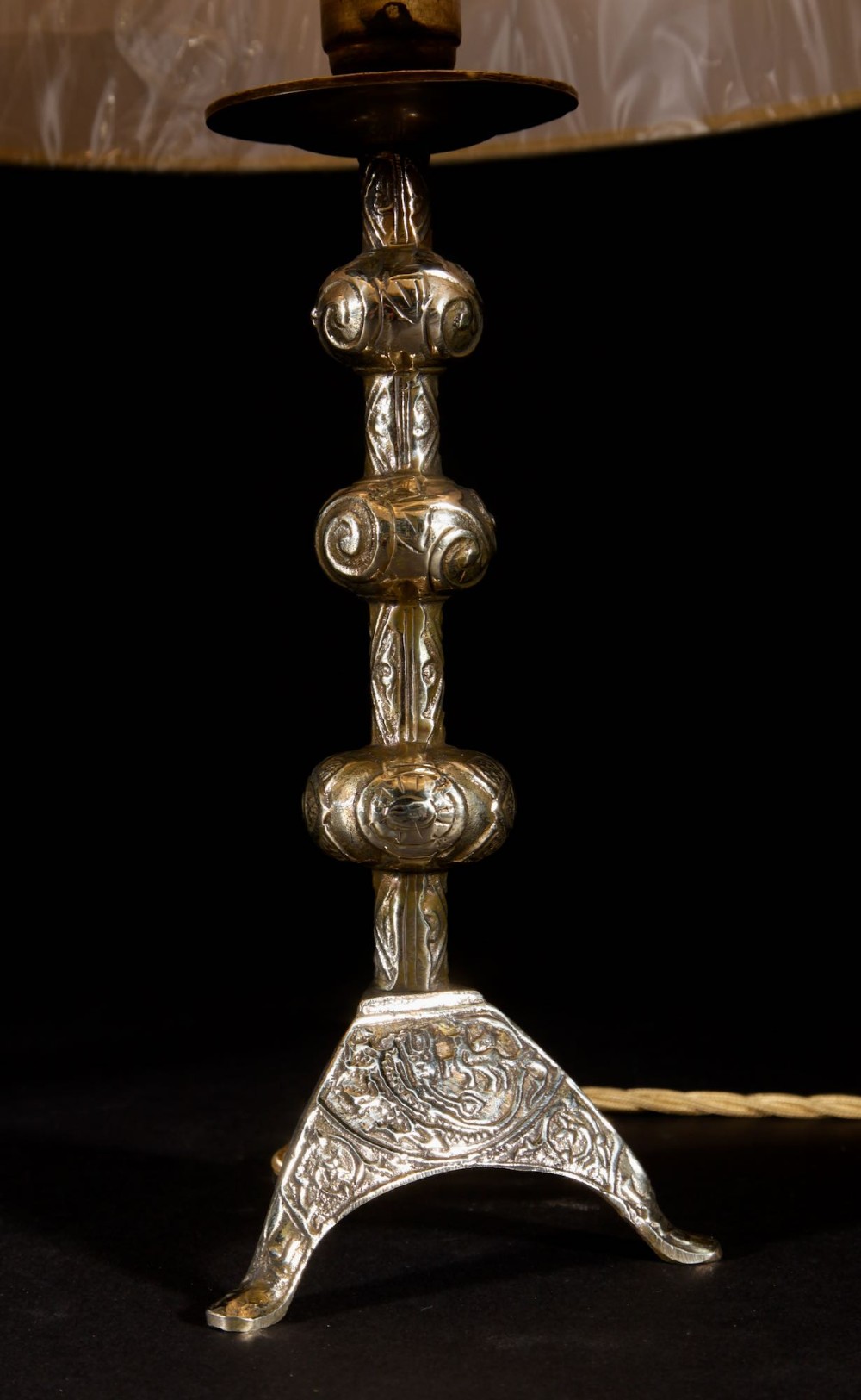 A pair of gold brass table lamps featuring relief-patterned shafts, tripod bases, and cream pleated shades. View V