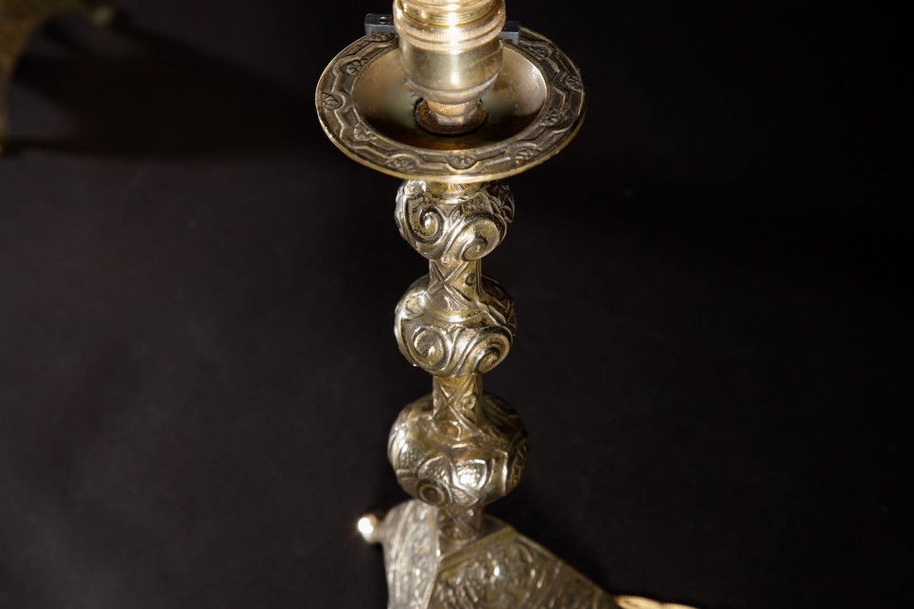A pair of gold brass table lamps featuring relief-patterned shafts, tripod bases, and cream pleated shades. View VIII