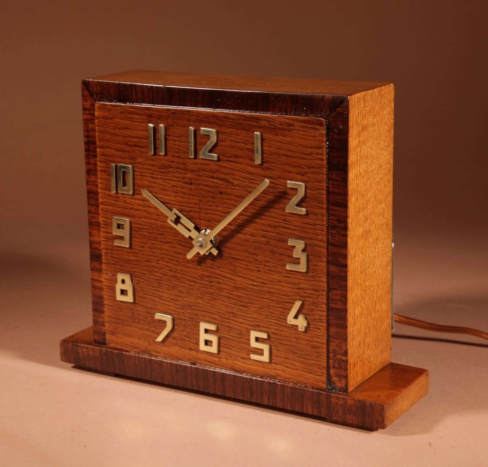 A square Art Deco wooden mantel clock crafted from oak and rosewood with applied brass numerals and hands. View II