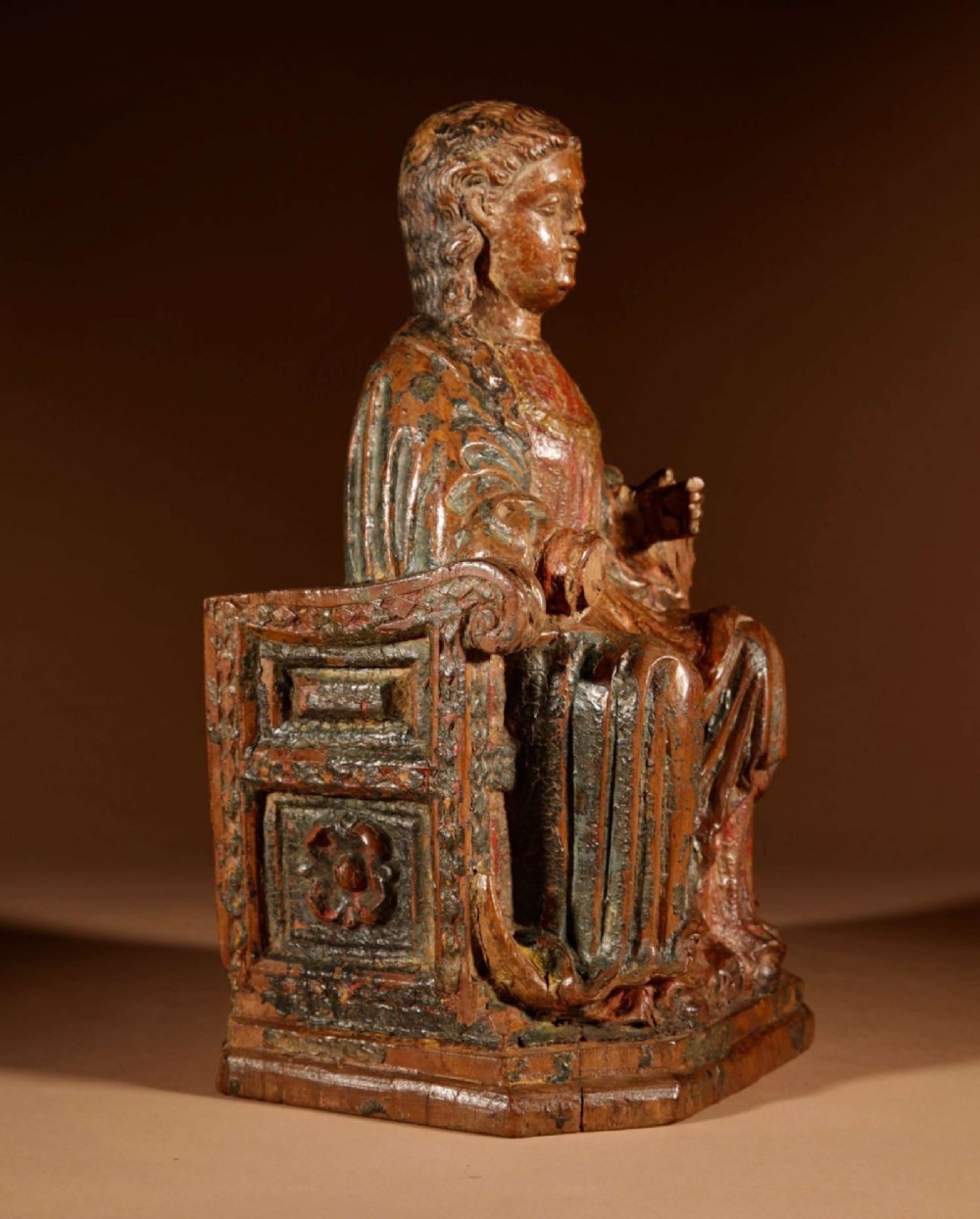 A 16th-century carved walnut statue depicting the Madonna seated on a throne with visible remnants of red and green polychrome paint. View IV