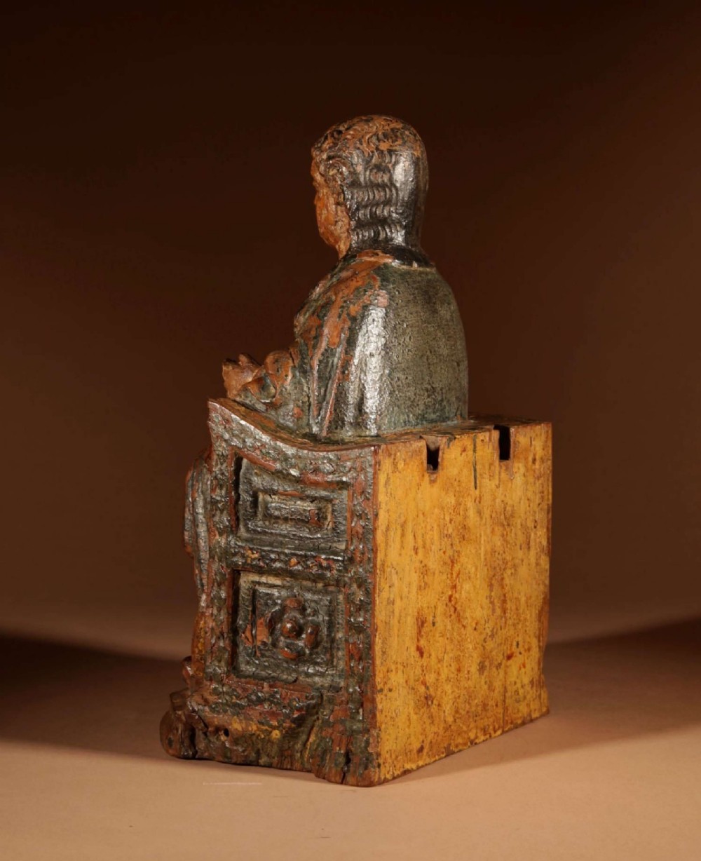 A 16th-century carved walnut statue depicting the Madonna seated on a throne with visible remnants of red and green polychrome paint. View VI