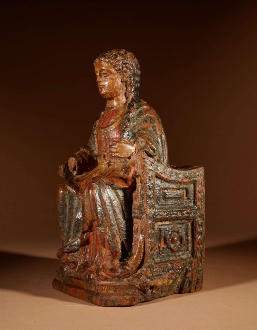 A 16th-century carved walnut statue depicting the Madonna seated on a throne with visible remnants of red and green polychrome paint. View VIII