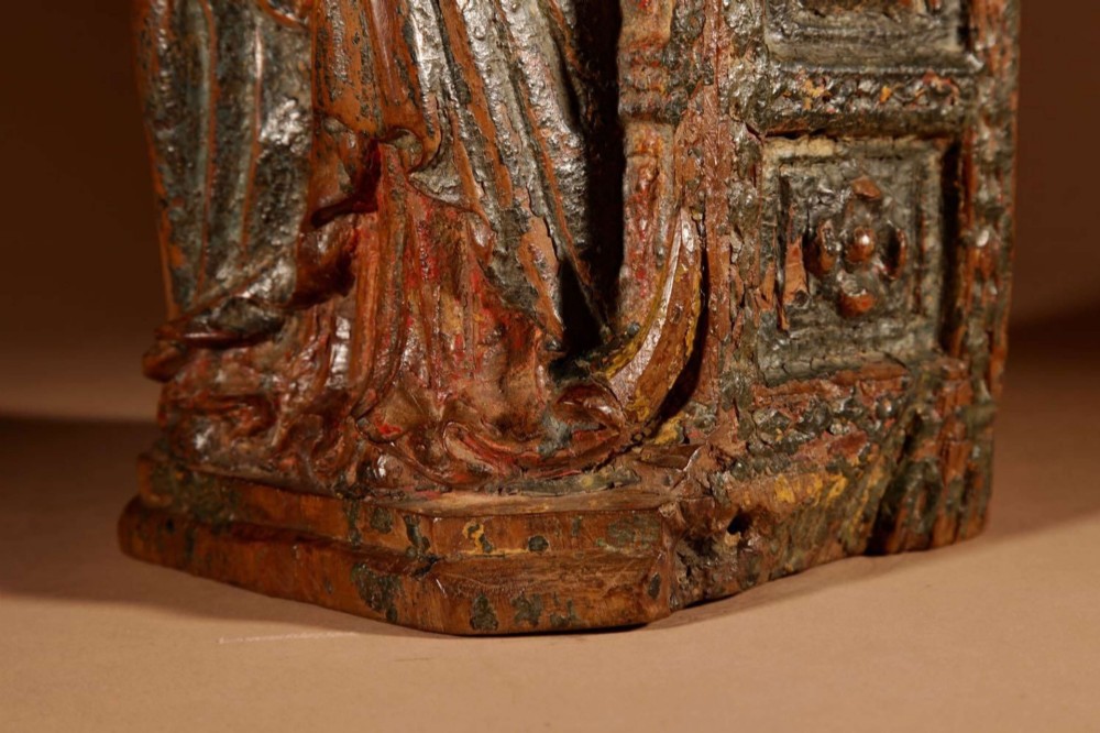 A 16th-century carved walnut statue depicting the Madonna seated on a throne with visible remnants of red and green polychrome paint. View IX