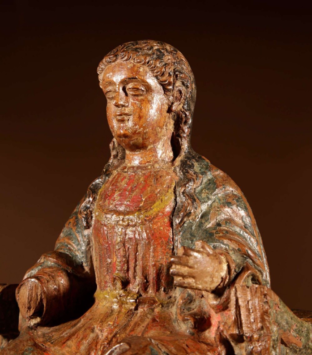 A 16th-century carved walnut statue depicting the Madonna seated on a throne with visible remnants of red and green polychrome paint. View XI