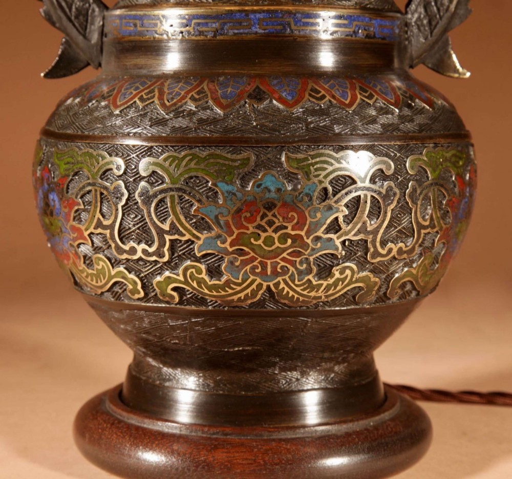 An antique Japanese bronze urn converted into a table lamp, featuring colourful Champleve enamel motifs, twin handles, and a cream pleated shade. View III