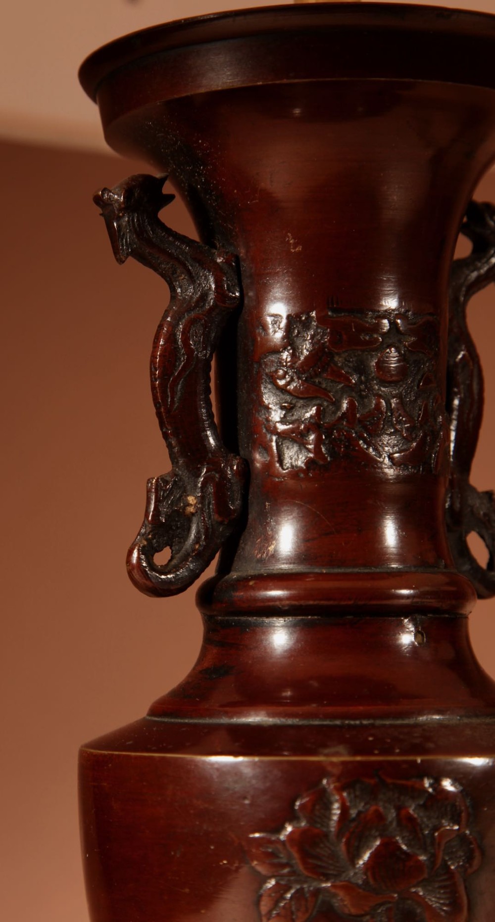 A matching pair of dark patinated bronze vase-shaped table lamps with dragon handles and pleated cream lampshades. View V
