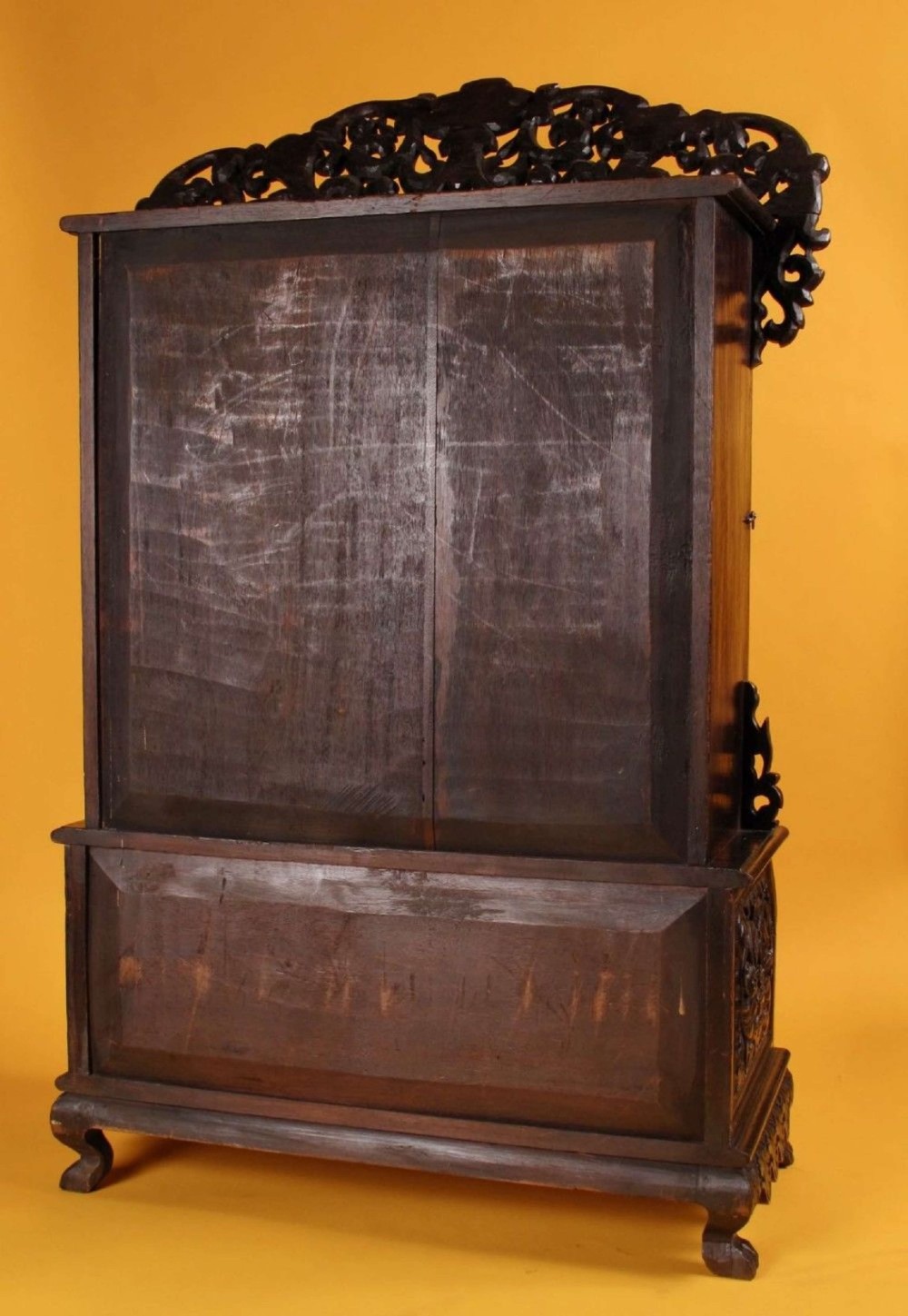 A 19th-century Anglo-Indian dark hardwood small display cabinet featuring intricate pierced foliate carvings, an arched pediment, a glazed four-pane door with scalloped moulding, and two carved drawers at the base. View VIII