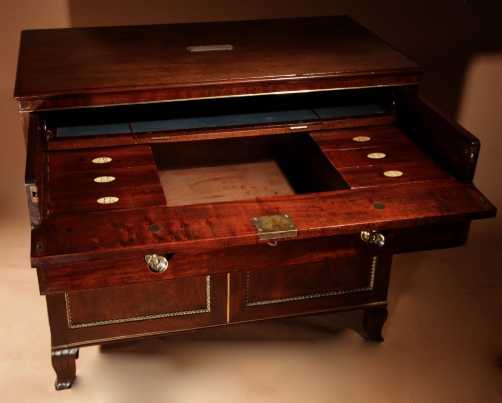 A Regency mahogany library secretaire featuring a pull-out writing drawer with an adjustable slope, brass handles, and lower cabinet doors opening to reveal pull-out tray shelves. View V