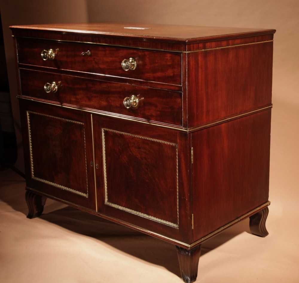 A Regency mahogany library secretaire featuring a pull-out writing drawer with an adjustable slope, brass handles, and lower cabinet doors opening to reveal pull-out tray shelves. View VI