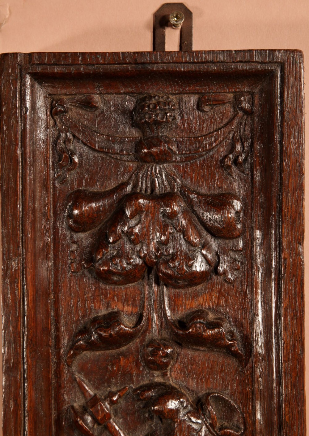 A wall-mounted candle sconce featuring a carved dark oak backboard and a curved brass arm holding a tray with four white candles. View VI