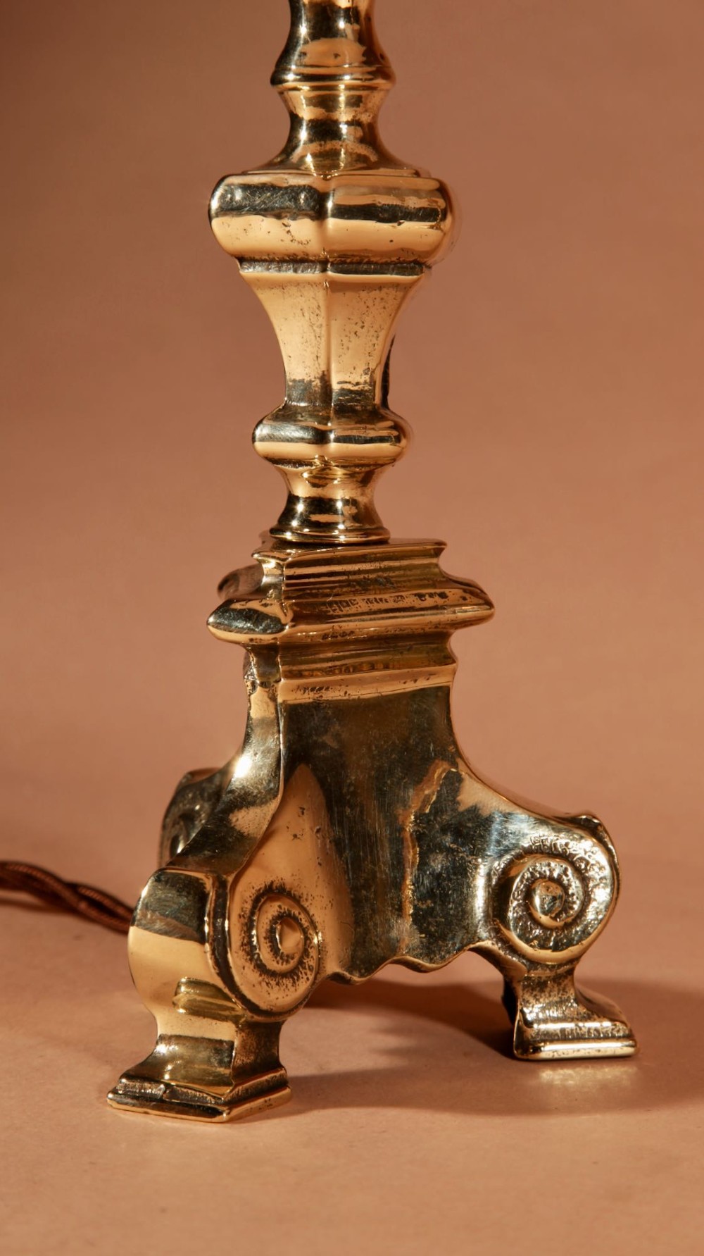 A pair of cast brass table lamps featuring turned baluster shafts, scroll-footed bases, and pleated cream fabric shades. View V