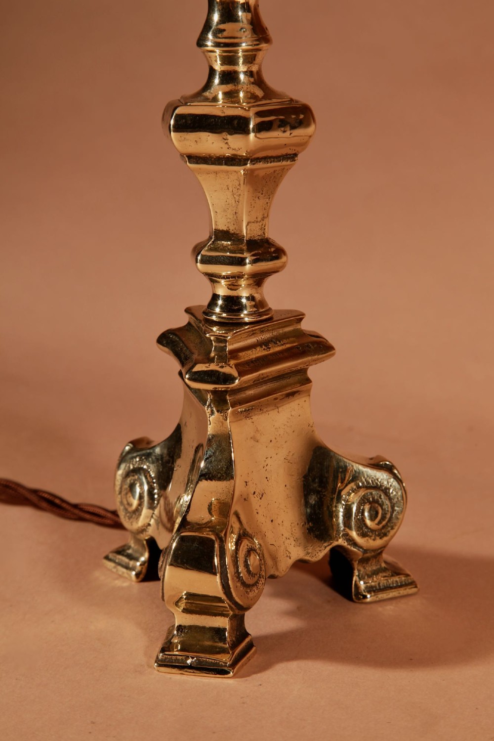 A pair of cast brass table lamps featuring turned baluster shafts, scroll-footed bases, and pleated cream fabric shades. View VI