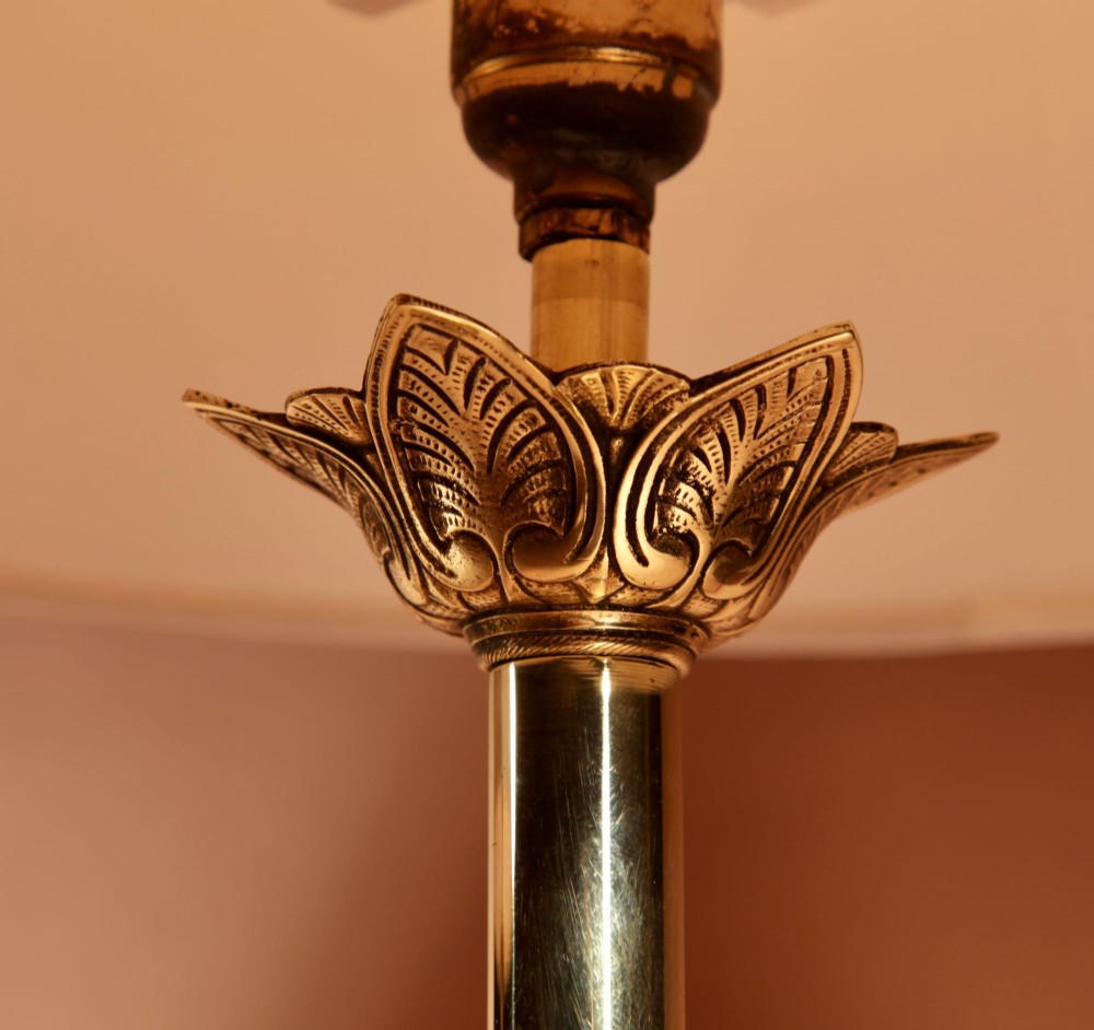 A pair of cast brass table lamps featuring knopped columns, pierced foliage bases, and off-white pleated shades. View II