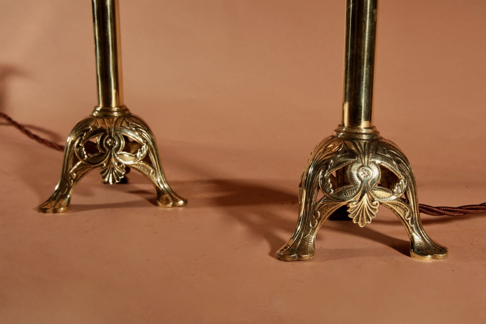 A pair of cast brass table lamps featuring knopped columns, pierced foliage bases, and off-white pleated shades. View VII