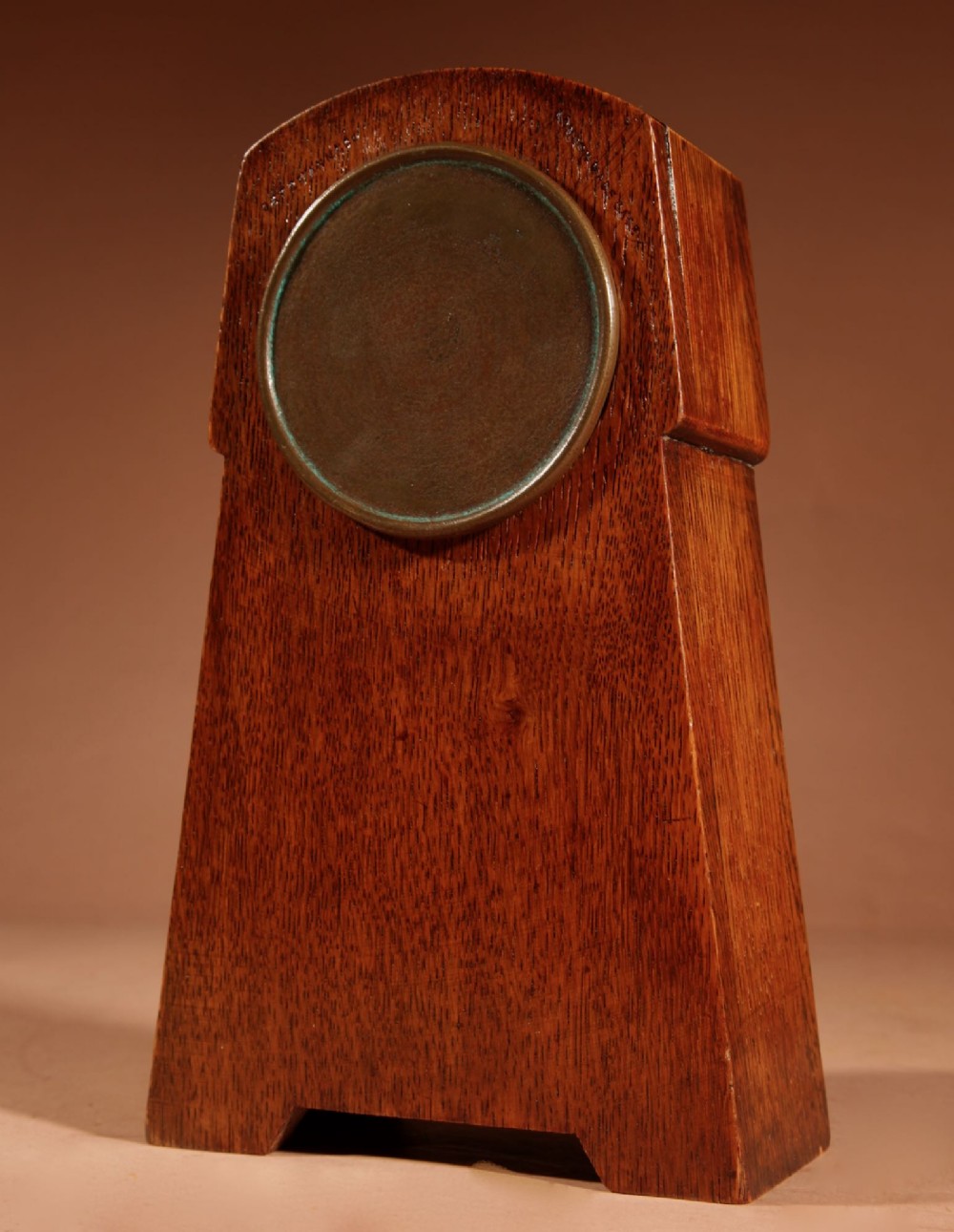 An Arts and Crafts tapered oak mantel clock featuring a white circular dial and wood inlay depicting an owl perched on a pewter crescent moon. View VII