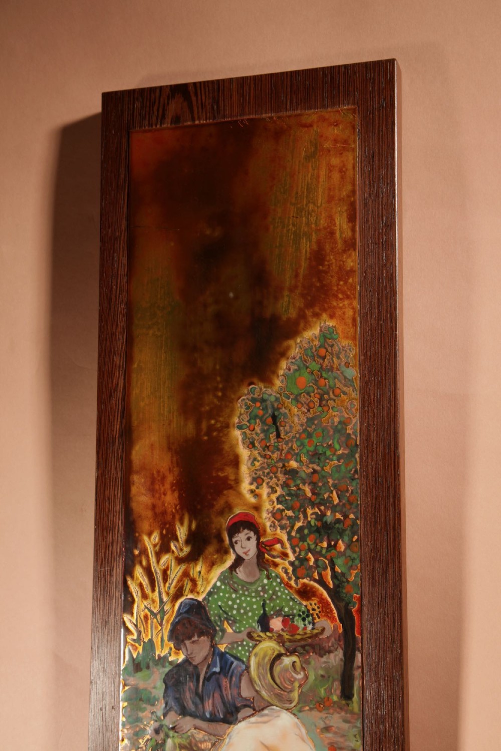 A vertical rectangular framed enamel on copper painting depicting three figures harvesting fruit in an orchard setting. View V