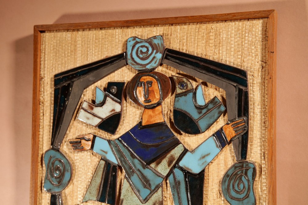A framed mid-century modern ceramic wall relief featuring stylised figures and birds in turquoise and blue glazes mounted on a woven background. View IV