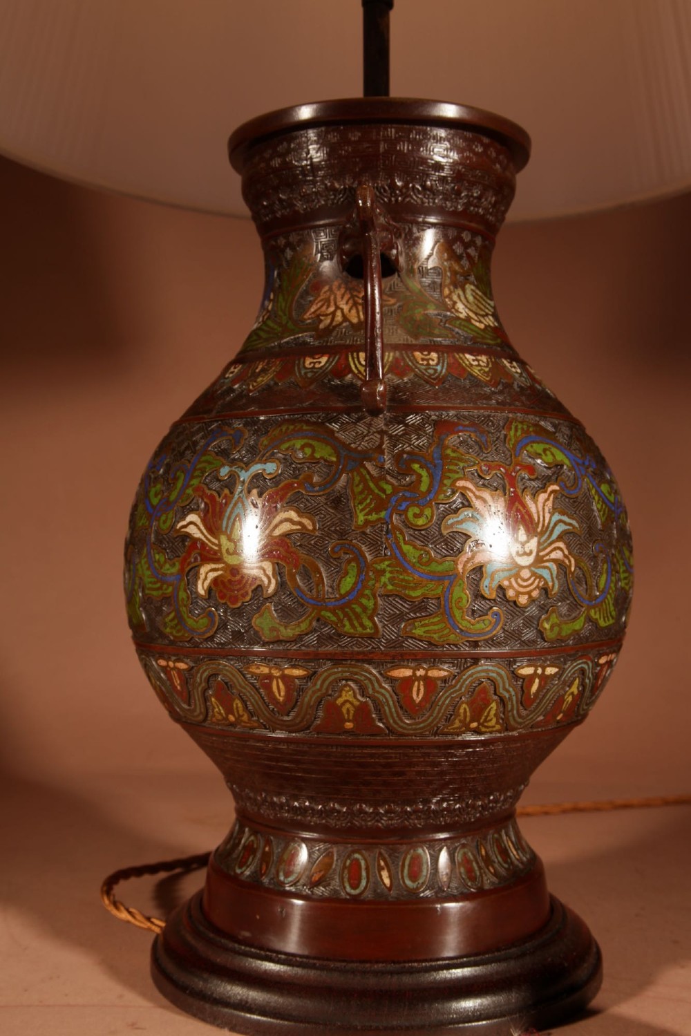 A Japanese champleve bronze vase lamp with ornate scroll handles and polychrome enamel detailing, topped with a pleated white shade. View VI