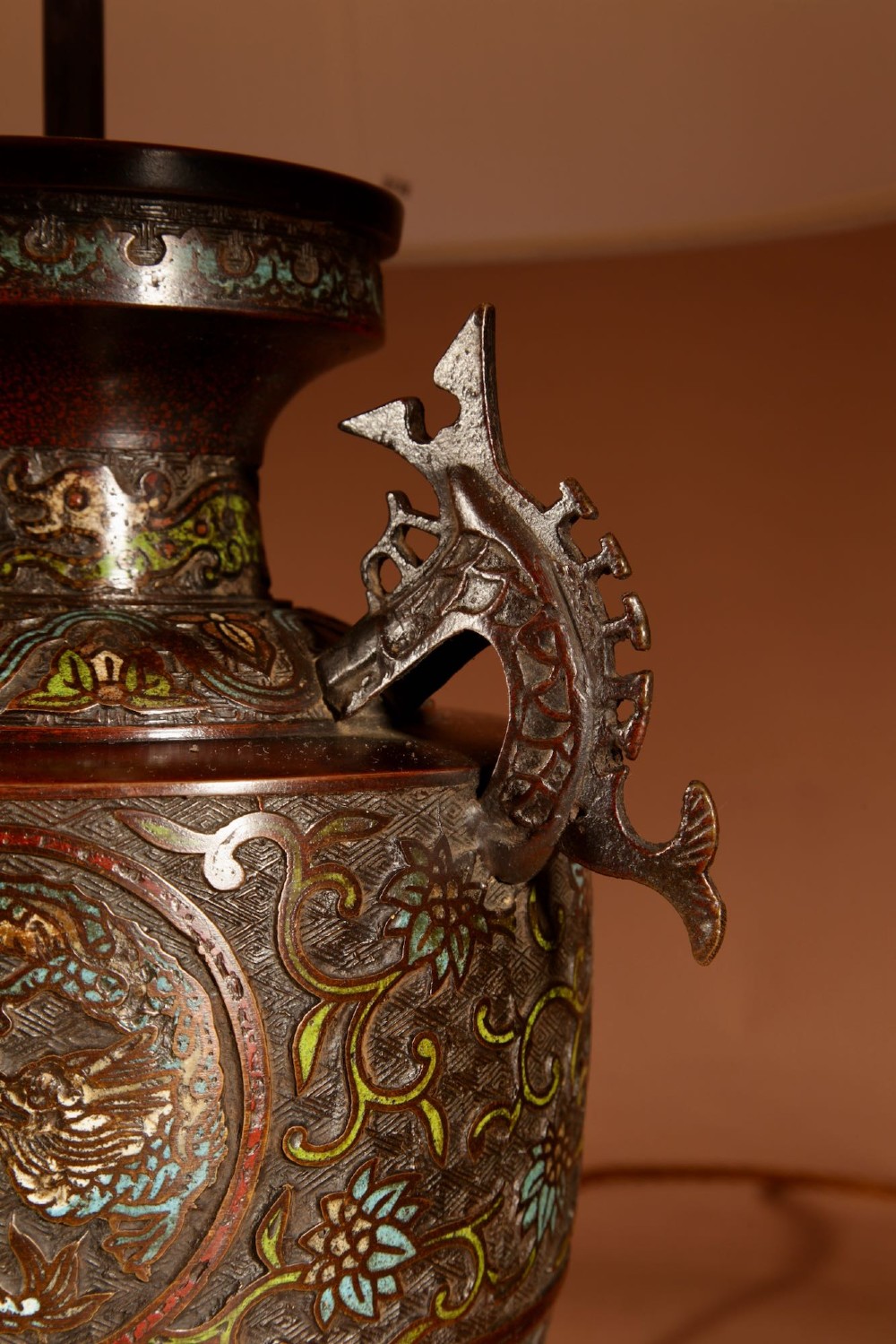 A Japanese champleve bronze vase base featuring cast dragon handles and polychrome enamel roundels, topped with a cream pleated shade. View V