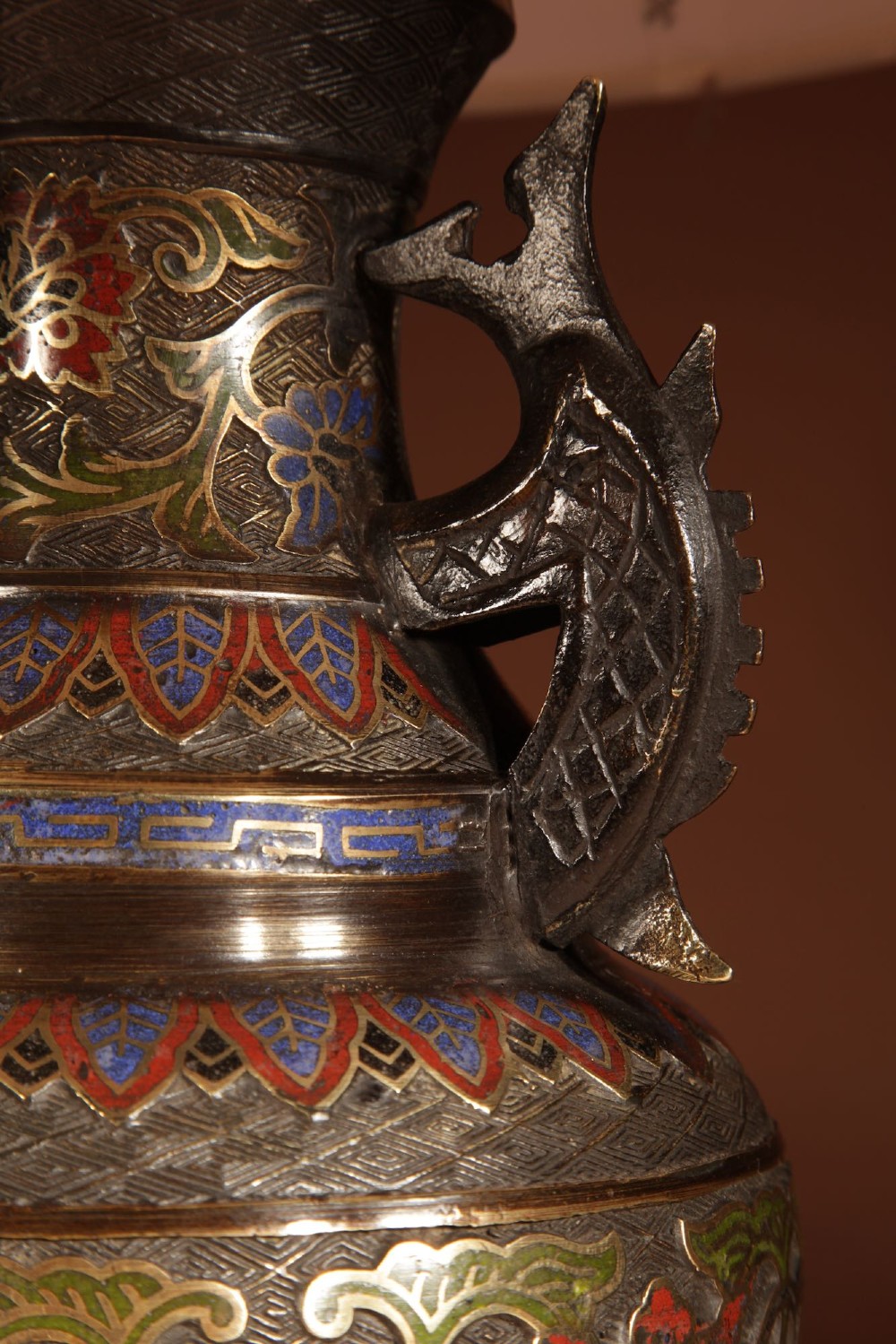A Japanese champleve bronze vase-form table lamp featuring cast dragon handles, colourful geometric enamel inlay, and a cream pleated shade. View VI