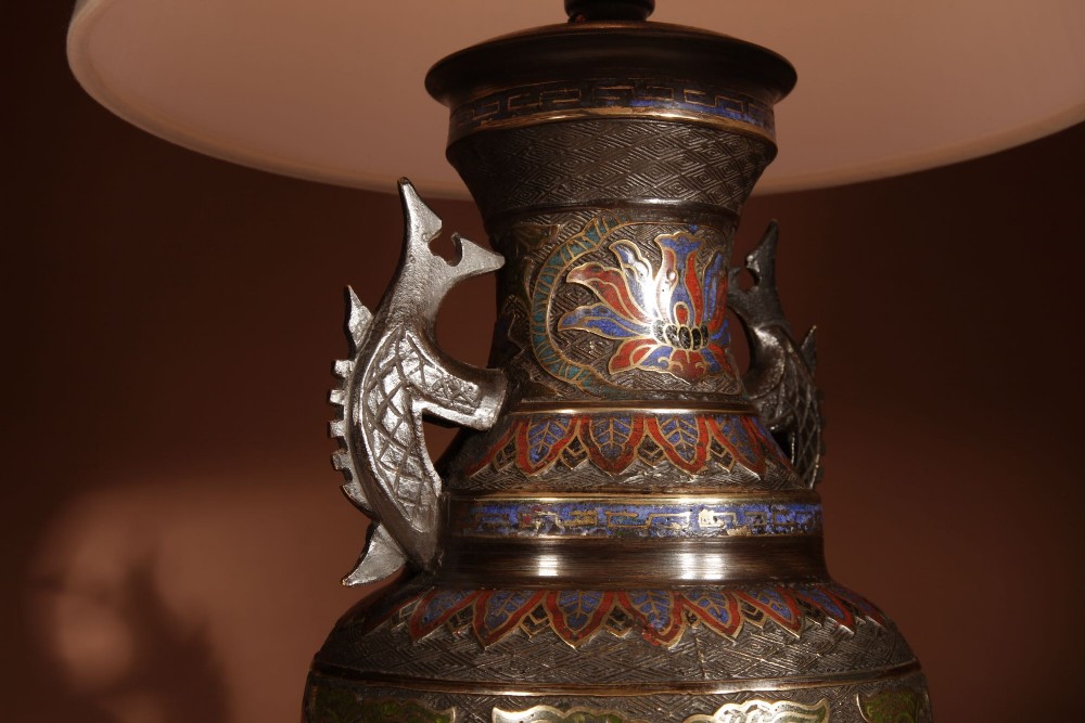 A Japanese champleve bronze vase-form table lamp featuring cast dragon handles, colourful geometric enamel inlay, and a cream pleated shade. View VII