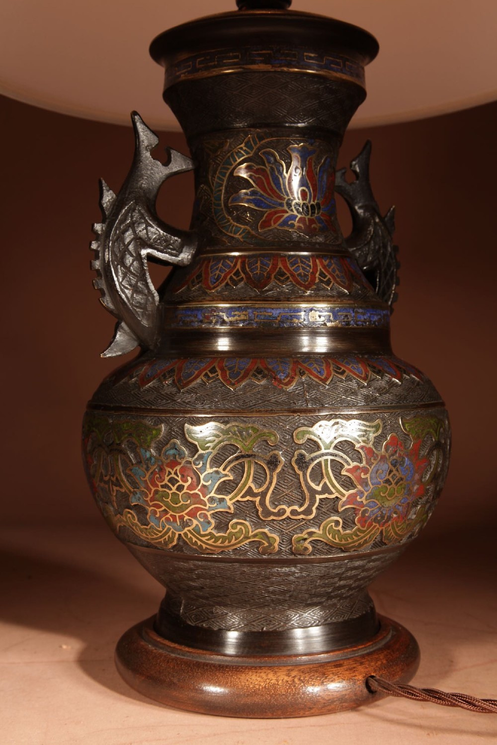 A Japanese champleve bronze vase-form table lamp featuring cast dragon handles, colourful geometric enamel inlay, and a cream pleated shade. View VIII