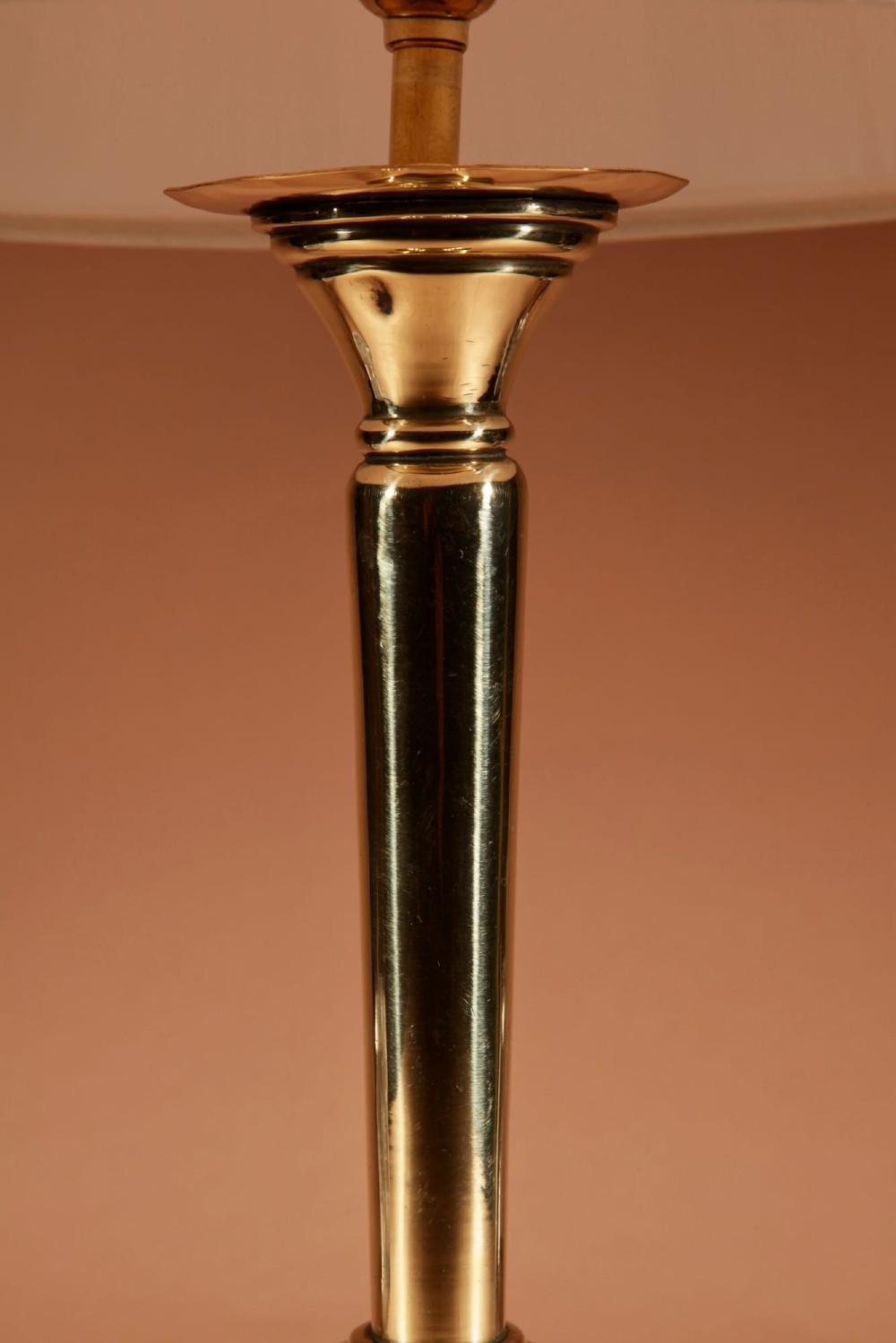 A polished brass column table lamp featuring a turned hardwood base and a cream pleated fabric lampshade. View V