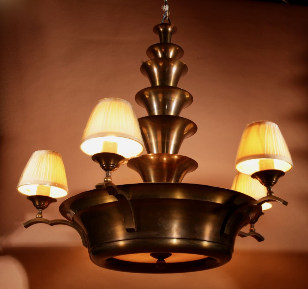 An Amsterdam School bronze five-light chandelier featuring a tiered central column and small pleated lampshades.
