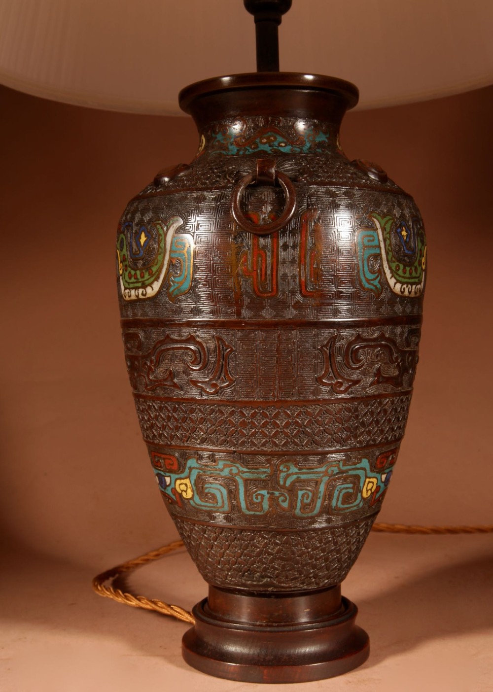 A Japanese cast bronze table lamp decorated with polychrome champleve enamel band motifs and fitted with a pleated cream shade. View V