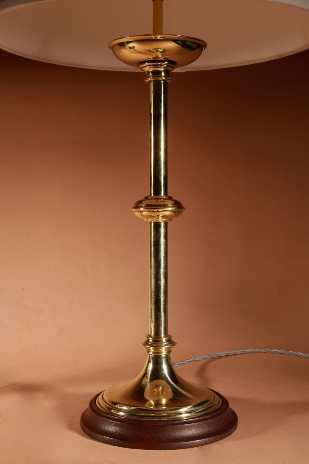 A pair of polished brass table lamps featuring knopped stems, circular timber bases, and cream pleated shades. View III
