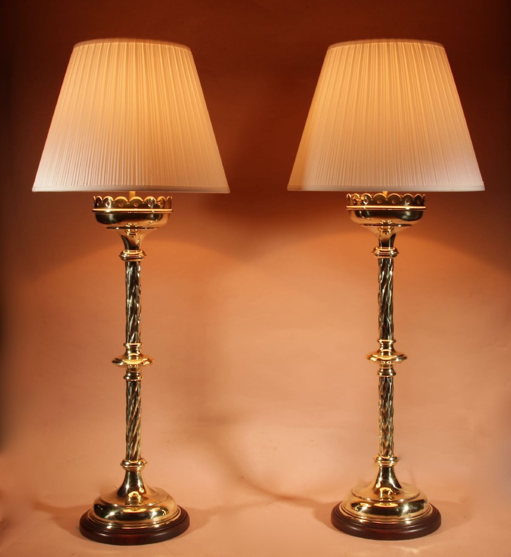 A pair of tall, polished brass Gothic style table lamps featuring spiral twist columns, wooden bases, and cream pleated shades. View II