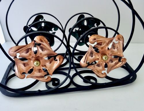 fig 1. An Arts and Crafts wrought iron music rack featuring curved wire dividers, a twisted handle, and stamped copper flower motifs on the front.