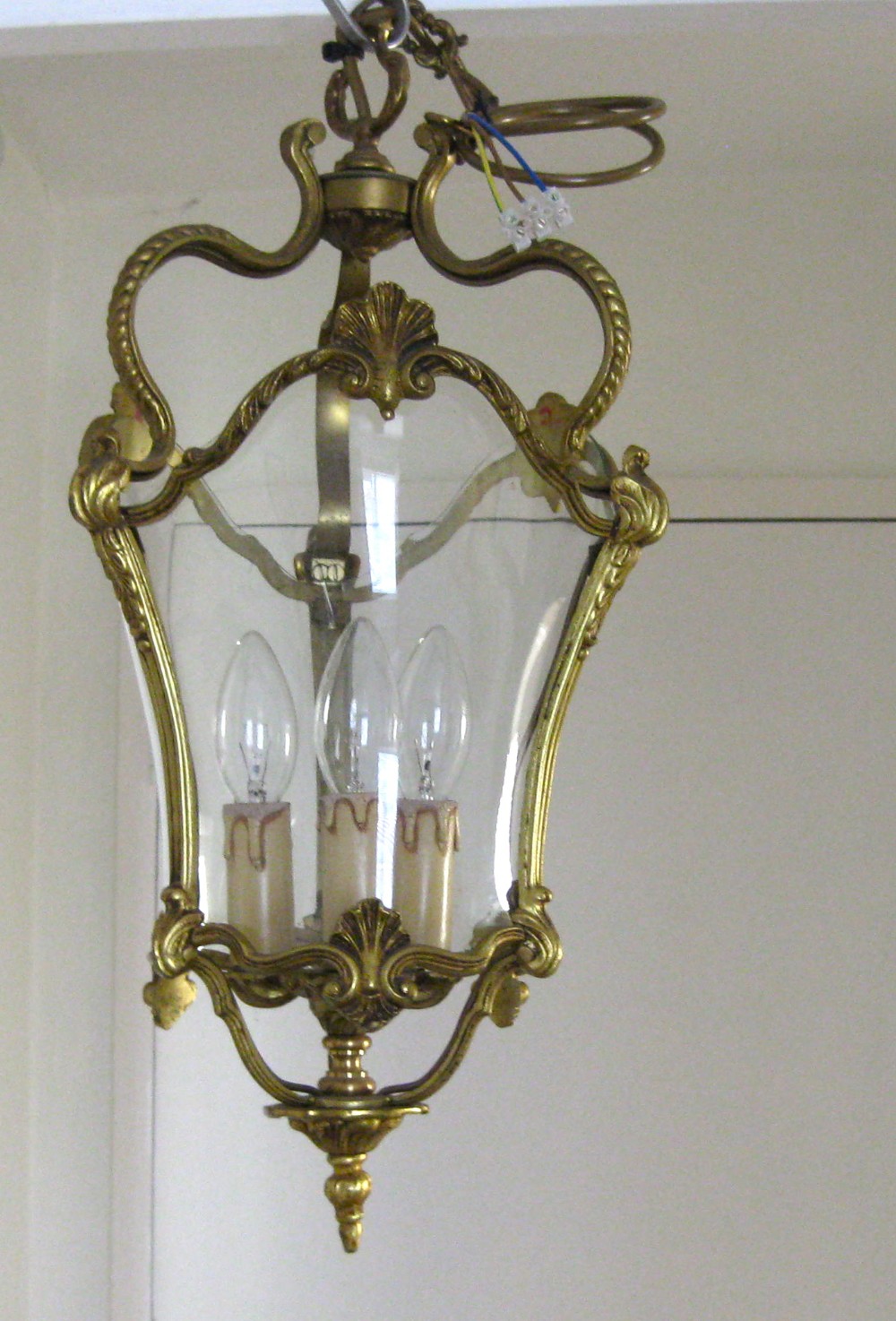 AN ANTIQUE BRASS HALL LANTERN WITH CURVED GLASS PANELS