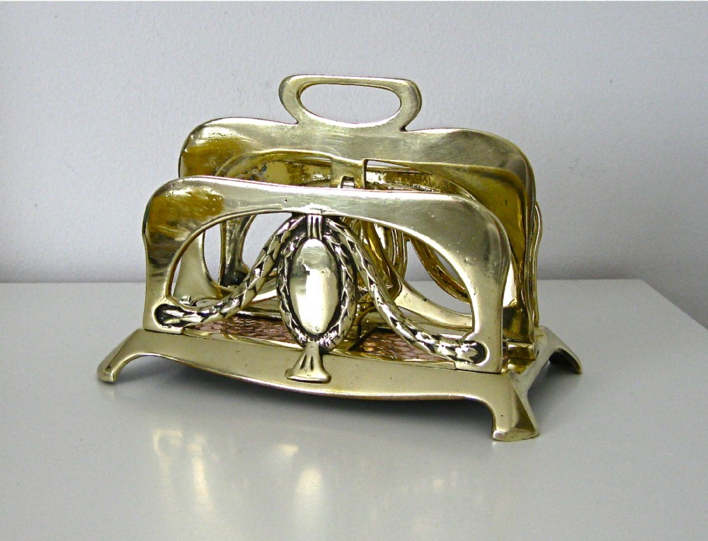 AN ART NOUVEAU BRASS AND COPPER LETTER RACK