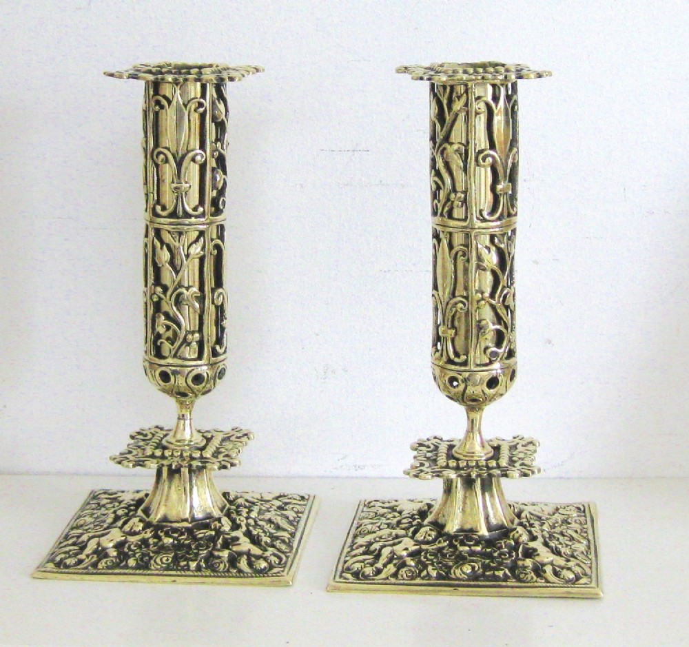 A PAIR OF ORNATE BRASS CANDLESTICKS