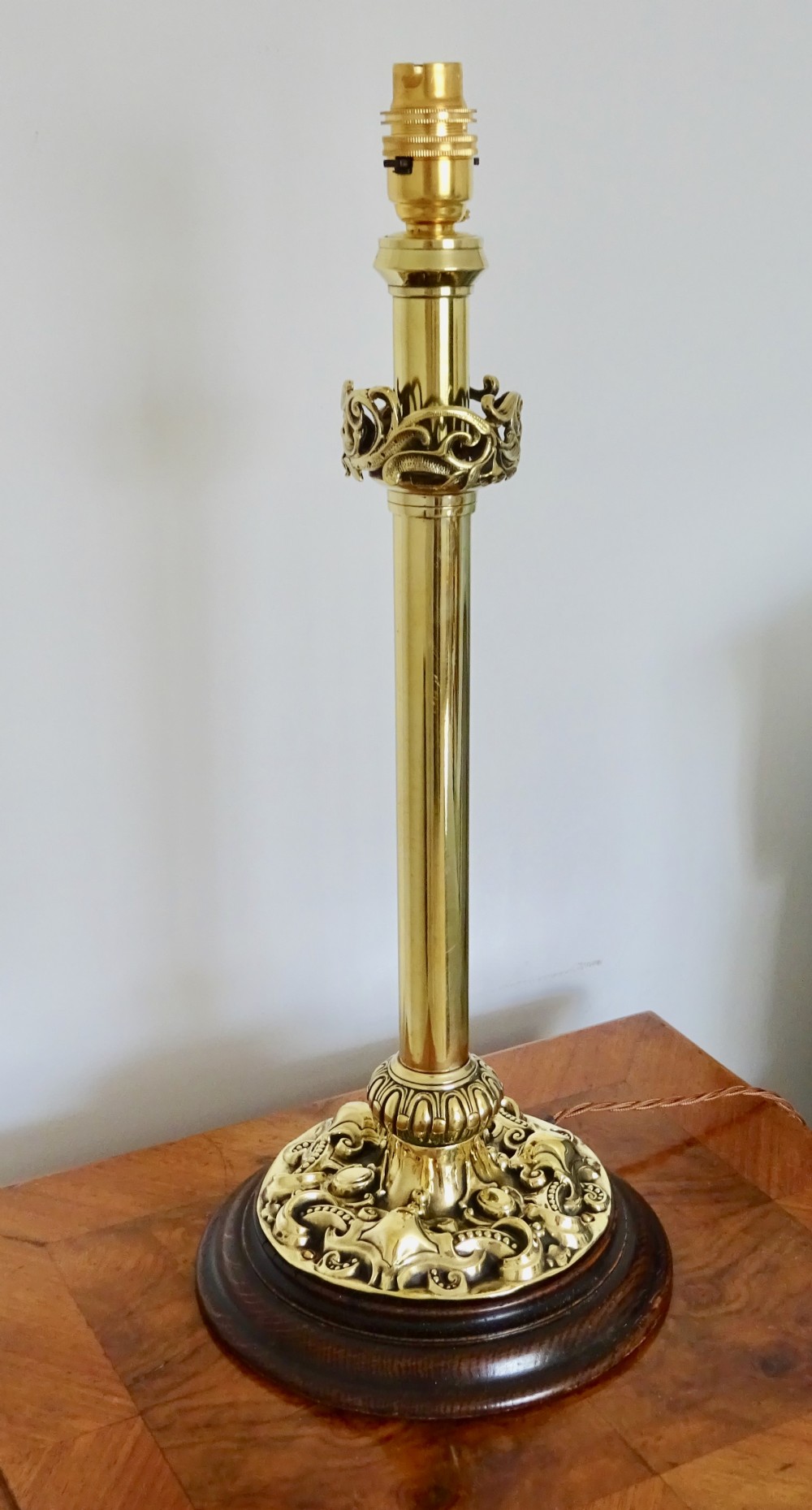 TALL EDWARDIAN BRASS LAMP ON A WOODEN BASE