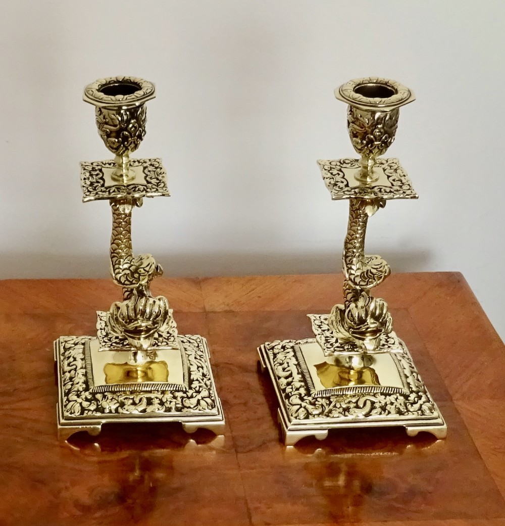 A PAIR OF VICTORIAN BRASS DOLPHIN CANDLESTICKS
