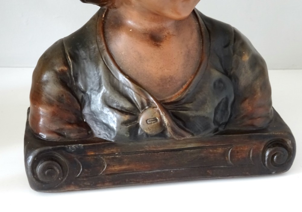 A 1930s French polychrome plaster bust depicting a young child wearing a hat, set upon a dark rectangular plinth with scrolled corners. View VII