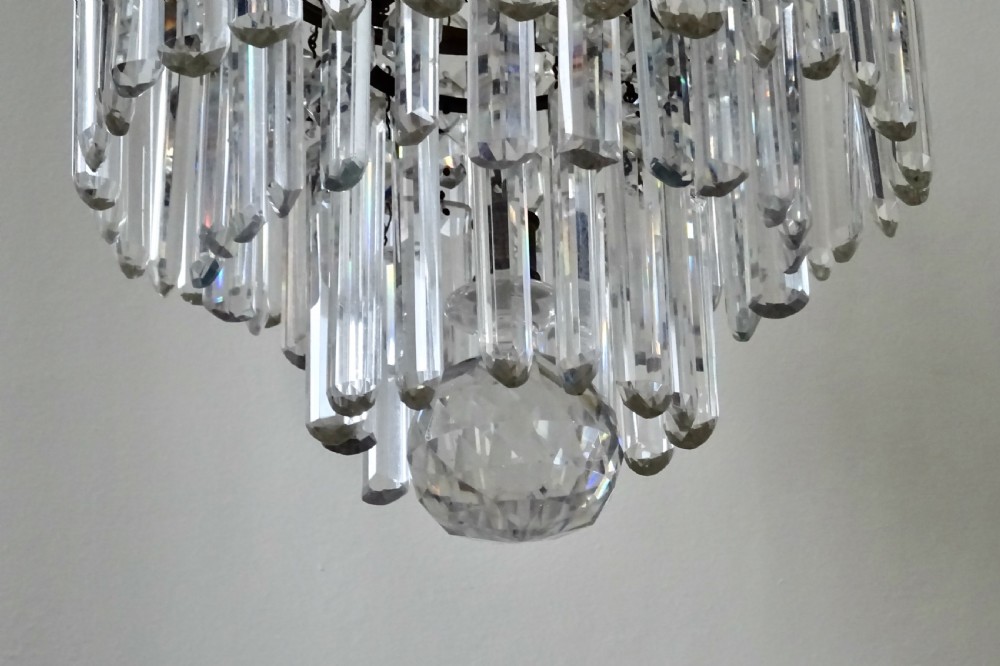 An Edwardian multi-tiered ceiling light featuring concentric rings of hanging cut crystal prisms suspended from a brass frame and chain. View III