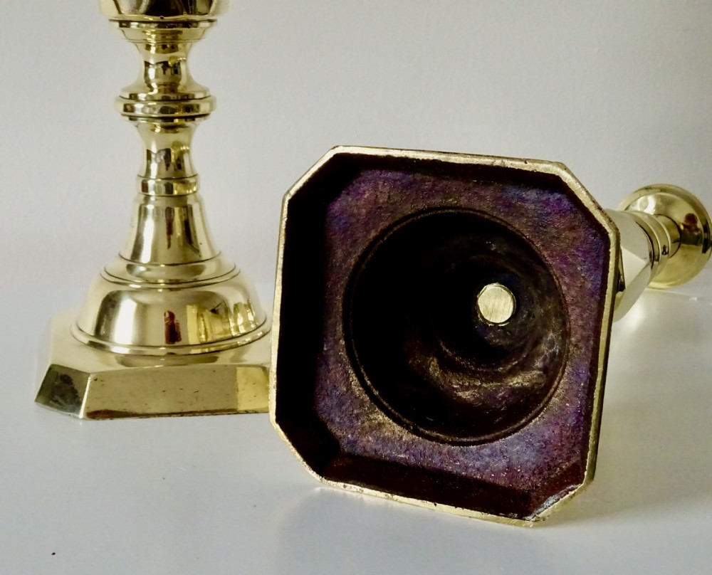 A pair of polished Victorian brass candlesticks with turned columns, faceted central knops, and square bases with cut corners. View VI
